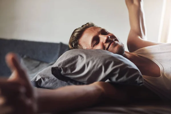 Ich bin heute frisch aufgewacht. Aufnahme eines gutaussehenden jungen Mannes, der morgens in seinem Bett zu Hause aufwacht. — Stockfoto