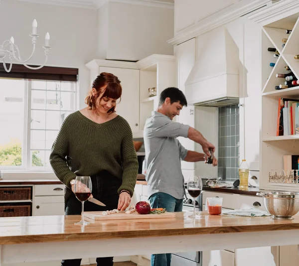 Nada sabe melhor do que uma refeição feita com amor. Corte tiro de um casal cozinhar juntos na cozinha em casa. — Fotografia de Stock