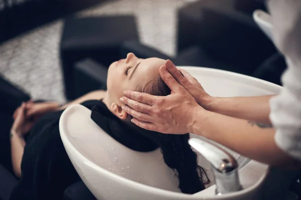 Vackert hår börjar med ett riktigt bra schampo. Skjuten av en vacker ung kvinna att få håret tvättat på salongen. — Stockfoto