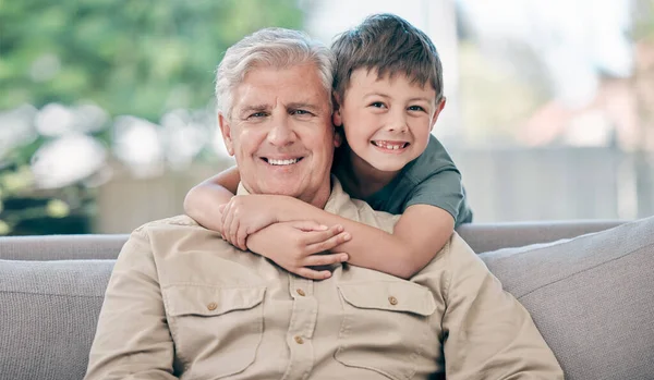 Vkládá pradědečka do pradědečka. Portrét rozkošného chlapečka relaxujícího se svým dědečkem na pohovce doma. — Stock fotografie