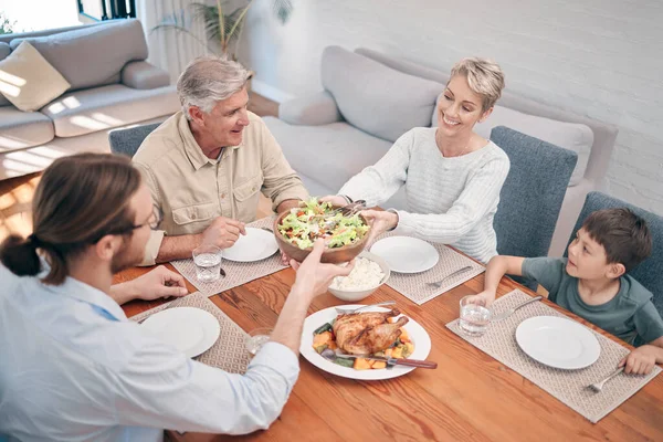 Cuando compartimos nuestra comida, compartimos nuestros corazones. Foto de una familia disfrutando de una comida juntos en casa. — Foto de Stock