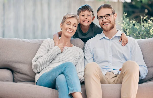 Three generations of love. Portrait of an adorable little boy relaxing with his grandmother and father on the sofa at home. — Stock Photo, Image