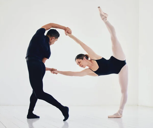 Supporto in postura. Studio shot di una giovane coppia che prova la loro routine. — Foto Stock