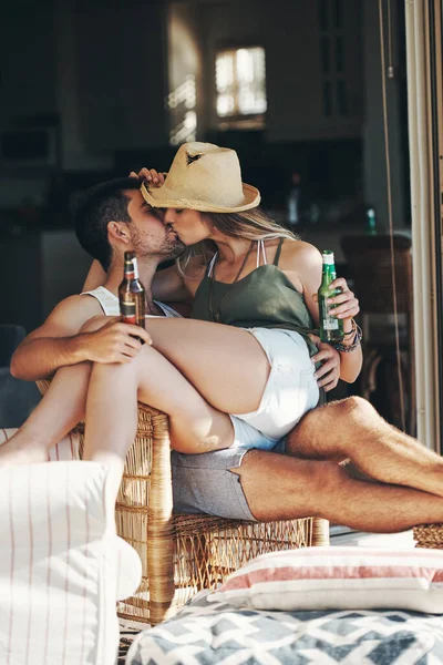 На вихідних разом. Обрізаний знімок ласкавої молодої пари цілується, насолоджуючись пивом на своєму патіо . — стокове фото