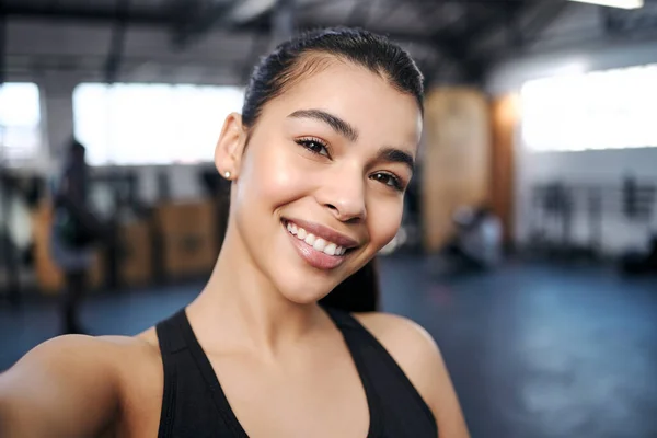 Svettiga selfies är sexiga selfies. Porträtt av en vältränad ung kvinna som tar selfies på gymmet. — Stockfoto