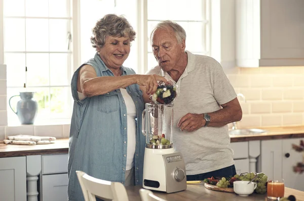 Today were making smoothies. Shot of a senior couple making a smoothie in the kitchen at home. — Stock Photo, Image