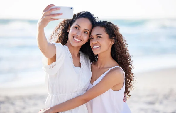 Qué suerte tengo de tenerla en mi vida. Fotografía de dos mujeres jóvenes tomando selfies en la playa. —  Fotos de Stock