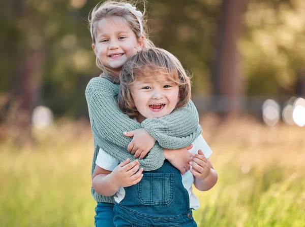 J'aime tellement mon petit frère. Tourné d'une adorable petite fille et son petit frère debout dehors. — Photo