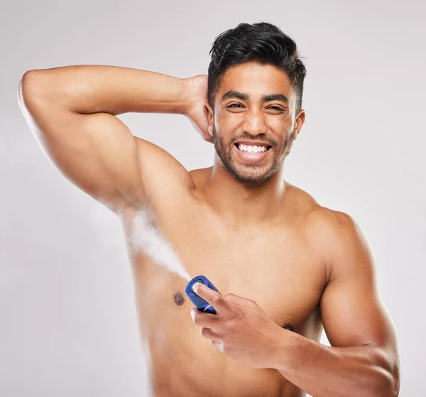 Felice di essere fresco e pulito. Girato di un giovane che applica il deodorante su uno sfondo grigio. — Foto Stock