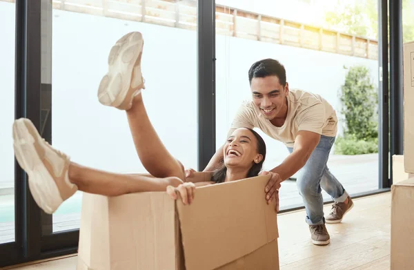 Vamos divertir-nos tanto aqui. Tiro de um jovem casal sendo brincalhão em sua nova casa. — Fotografia de Stock