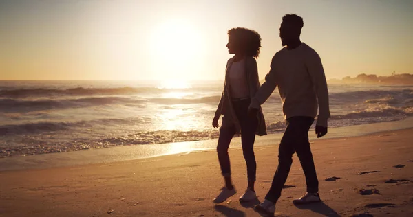 L'uno accanto all'altro in ogni aspetto della vita. Scatto completo di una giovane coppia affettuosa che passeggia sulla spiaggia al tramonto. — Foto Stock