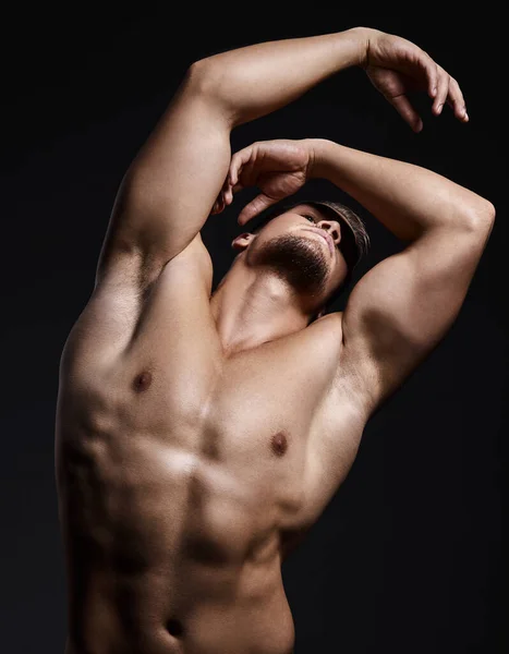 You can get the body you want but it wont happen overnight. Shot of a muscular young man posing against a black background. — Stock Photo, Image