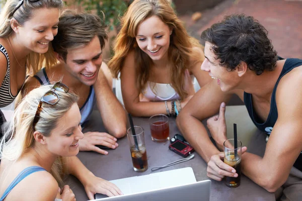 Regarde-moi ça. Groupe d'adolescents dégustant des boissons dans un restaurant en plein air avec toute leur technologie moderne. — Photo