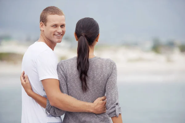 Lo único que importa es que es feliz. Foto de una joven pareja mirando las vistas de la playa. —  Fotos de Stock