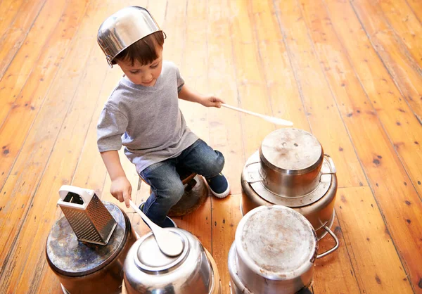 Дети зажигают. Выстрел очаровательного маленького мальчика, играющего на кастрюлях и сковородках. — стоковое фото