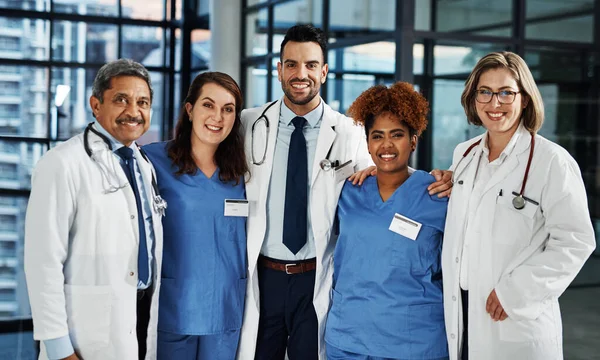 あなたの健康を念頭に置いて一緒に働く。病院に立っている自信のある医師のチームの肖像画. — ストック写真