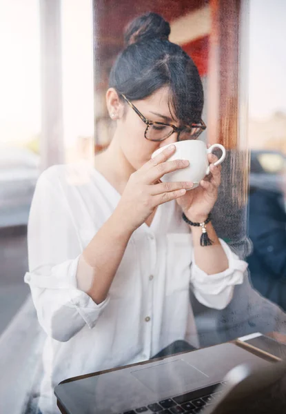 Solo un altro sorso. Foto ritagliata di una bella giovane donna che beve un sorso del suo caffè che ha appena comprato all'interno di un caffè durante il giorno. — Foto Stock