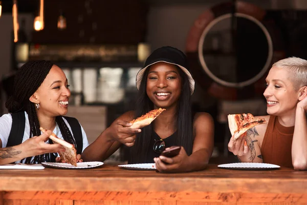 Пицца это одна из наших общих черт. Обрезанный снимок друзей, которые вместе едят пиццу в кафе. — стоковое фото