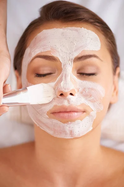 Een masker van schoonheid aanbrengen. Close-up van een schoonheidstherapeut toepassen van een gezichtsmasker op een klant. — Stockfoto