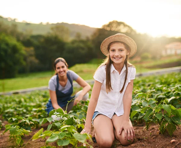 妈妈在教我怎么经营这个农场。一个年轻女孩和她的母亲在家庭农场干活的肖像. — 图库照片