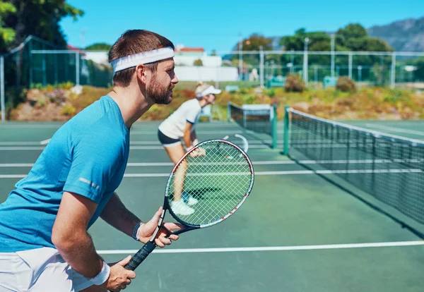 Entraînez-vous comme un champion si vous voulez en devenir un. Plan recadré d'un beau jeune joueur de tennis masculin jouant avec une coéquipière à l'extérieur sur un court. — Photo