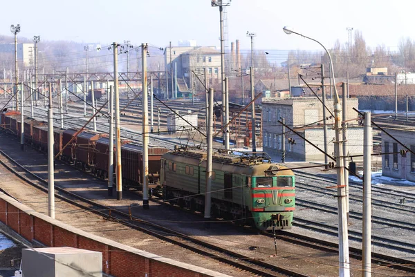 Die einzige Möglichkeit, in der Stadt zu reisen. Aufnahme eines Zuges auf den Gleisen mit Industrie im Hintergrund. — Stockfoto