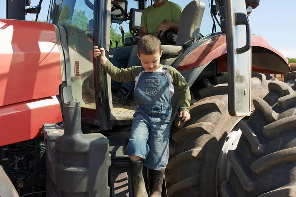 Fueron días difíciles trabajando. Un disparo de un niño bajando de un tractor. — Foto de Stock