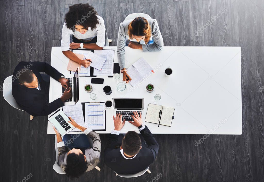 Gaining a lead together. High angle shot of a group of businesspeople having a meeting in an office.