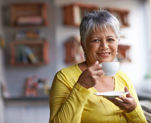 Mi godo una tazza di caffe 'al mattino. Ritratto di una donna matura che si gode una bevanda calda in una caffetteria. — Foto Stock