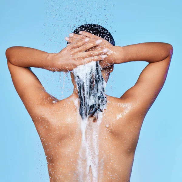 You dont need your eyes to see a confident woman. Rearview shot of an unrecognizable woman enjoying a soapy shower against a blue background. — Stock Photo, Image