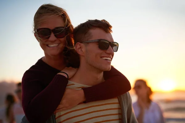 Ik ben blij als ik hem dichtbij heb. Gehakt schot van een aanhankelijke jongeman meeliften zijn vriendin op het strand. — Stockfoto