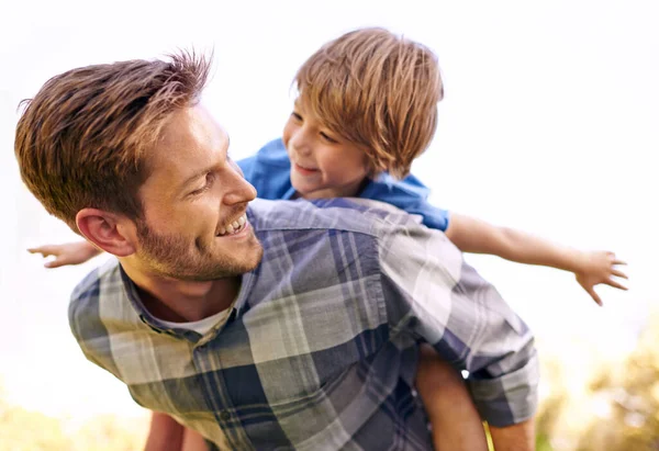 Hij houdt zoveel van zijn zoontje. Gehakt schot van een jonge vader geven zijn zoon een piggyback rit. — Stockfoto