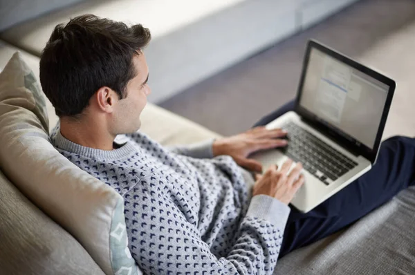 Hij traint z 'n vingers. Een jongeman werkt aan zijn laptop in zijn leven.. — Stockfoto