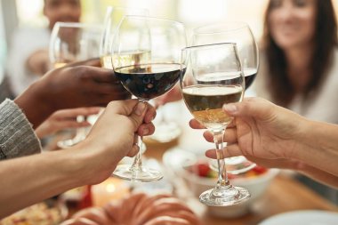Biraz şarap iç, çok gül. Yemek masasında kadeh kaldıran bir grup insanın görüntüsü..