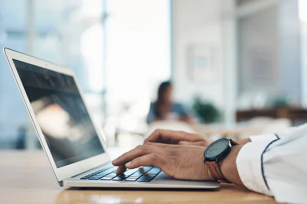 Zoek wat hij nodig heeft op het net. Close-up van een onherkenbare zakenman met een laptop in een kantoor. — Stockfoto