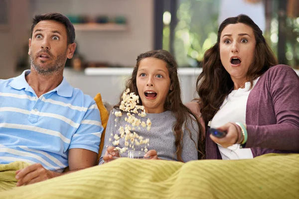 무서운 영화를 좋아하거든요. 한 가족 이 거실 소파에 앉아 영화를 보고 팝콘을 먹는 모습. — 스톡 사진