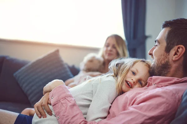 Ama-os, nutre-os, cuida deles. Tiro de uma adorável jovem família de quatro relaxantes juntos no sofá em casa. — Fotografia de Stock