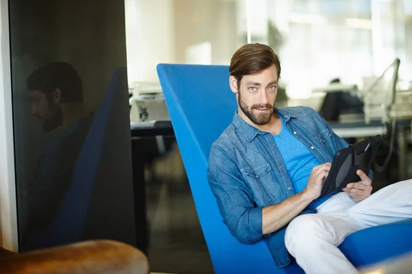 Cuidar de los negocios en línea. Retrato de un joven empresario usando una tableta digital mientras está sentado en una oficina. — Foto de Stock