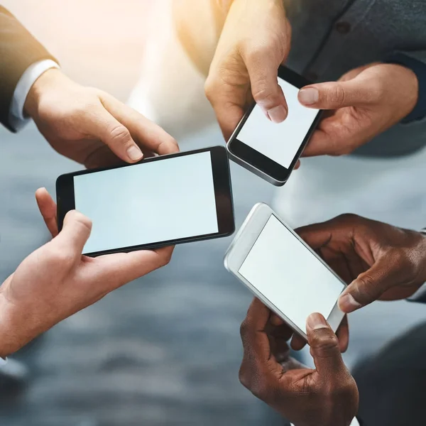 Die intelligente und nahtlose Integration von Technologie in den Arbeitsplatz. Aufnahme einer Gruppe unkenntlich gemachter Geschäftsleute mit ihren Mobiltelefonen im Büro. — Stockfoto