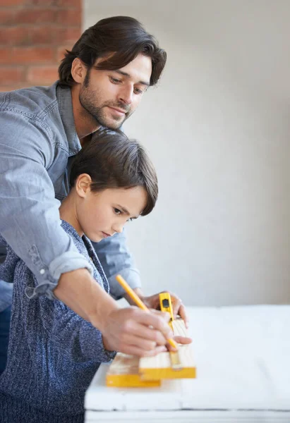 Imparare tutto cio 'che papa' ha da insegnare. Un padre e un figlio che lavorano insieme sul legno. — Foto Stock