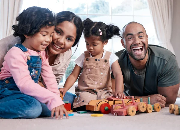 Há alegria em estarmos juntos. Retrato de uma família feliz brincando junto com brinquedos de madeira em casa. — Fotografia de Stock