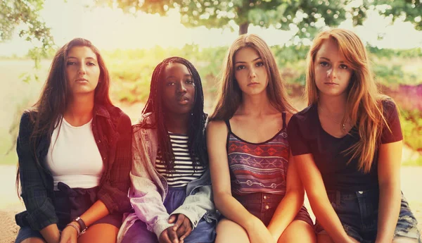 Bis jetzt waren sie so amüsiert.... Eine Gruppe missmutig dreinblickender Teenager-Mädchen sitzt draußen. — Stockfoto