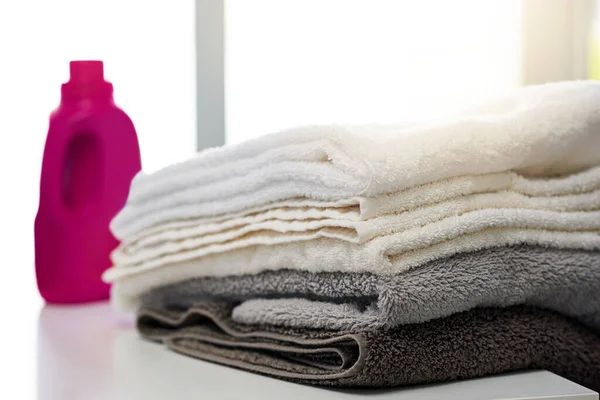 Puhdas ja tuore. Laukaus pesuainetta ja kasa viikattuja pyyhkeitä kotona.. — kuvapankkivalokuva