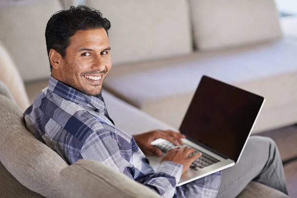 Getting to work on my blog. A young man working on his laptop from home. Stock Photo