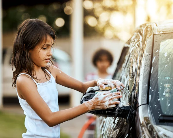 Obtener el coche agradable y limpio. Fotografía de una niña alegre lavando el coche de sus padres durante el día. — Foto de Stock