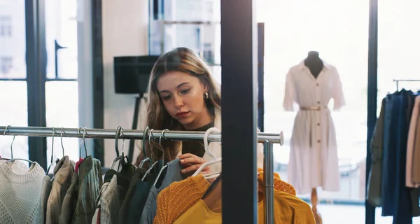 Einfach nur stöbern. Aufnahme einer jungen Frau, die in einer Boutique durch Kleider stöbert. — Stockfoto