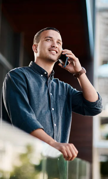 Het is tijd om je naam bekend te maken. Foto van een jonge zakenman die op een balkon op kantoor staat en een smartphone gebruikt. — Stockfoto