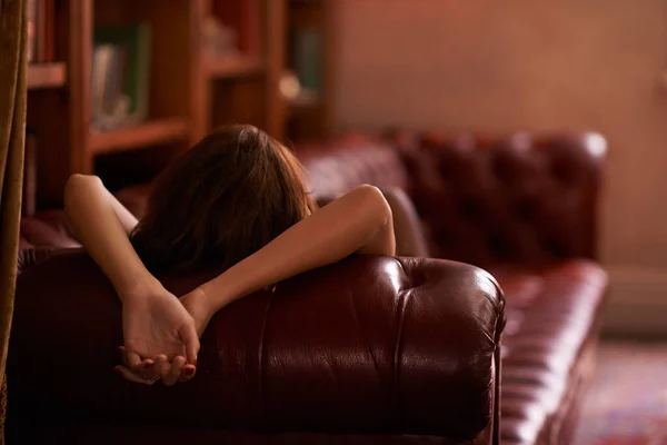 ソファで私と合流するように気をつけなさい。研究ではソファの上でリラックスした若い女性の後景ショット. — ストック写真