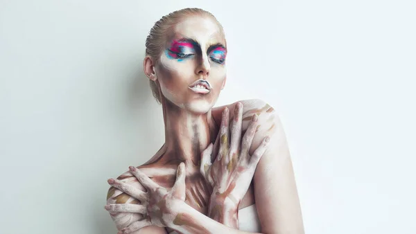 Umarmt das Seltsame. Studioaufnahme einer jungen Frau, die mit Farbe im Gesicht posiert. — Stockfoto