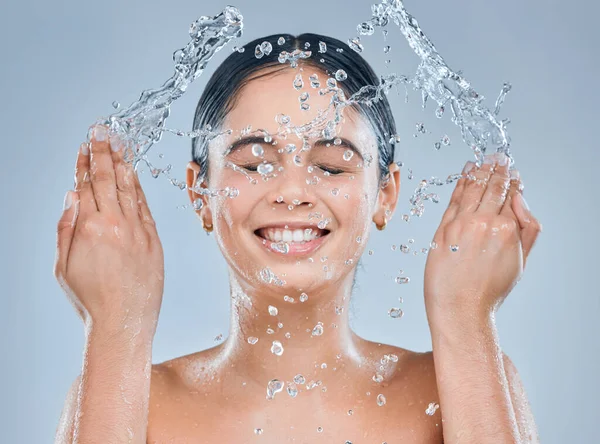 Invierte en un buen cuidado de la piel. Foto de una joven lavándose la cara en la ducha sobre un fondo gris. —  Fotos de Stock